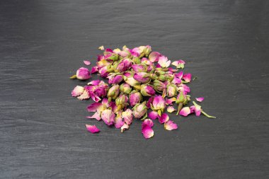 Kuru Gül Tomurcukları, Pembe Çiçek Çayı için Gül Yaprakları, Kurumuş Pers Gülleri, Siyah Taş Tabaka Arkaplanındaki Gül Tomurcukları