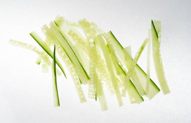 İzole edilmiş salatalık, salatalık dilimleri, salata için yeşil sebze dilimleri, sağlıklı doğal bitki parçaları, beyaz arka planda kesilmiş makro salatalıklar.