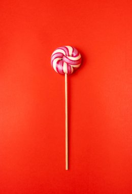 Renkli lolipop, çubukta sarmal şeker, renkli çizgili lolipop, yuvarlak meyveli karamel, çok renkli şekerleme, kırmızı arka planda daire şeklinde lolipop, metin için kopyalama alanı