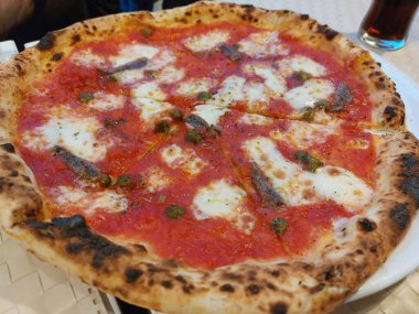 Restoran Tabağında Ançüez Pizza, Domatesli Makro Balık Pizza ve Açık Cafe 'de Mozzarella Peyniri, Bulanık Arkaplanda Geleneksel İtalyan Düz Ekmek Dokusu, Seçici Odaklanma