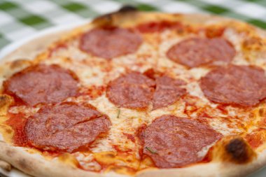 Restoran Tabağında Pepperoni Pizza, Domatesli Macro Salami Pizza ve Açık Cafe 'de Mozzarella Peyniri, Bulanık Arkaplanda Geleneksel İtalyan Düz Ekmek Dokusu, Seçici Odaklanma
