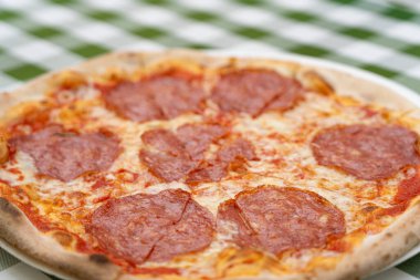 Restoran Tabağında Pepperoni Pizza, Domatesli Macro Salami Pizza ve Açık Cafe 'de Mozzarella Peyniri, Bulanık Arkaplanda Geleneksel İtalyan Düz Ekmek Dokusu, Seçici Odaklanma