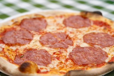 Restoran Tabağında Pepperoni Pizza, Domatesli Macro Salami Pizza ve Açık Cafe 'de Mozzarella Peyniri, Bulanık Arkaplanda Geleneksel İtalyan Düz Ekmek Dokusu, Seçici Odaklanma
