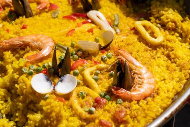 Seafood paella, Spanish rice dish with shrimp, mussels, clams, yellow rice in large pan. Traditional Spanish paella at outdoor market, street food clipart