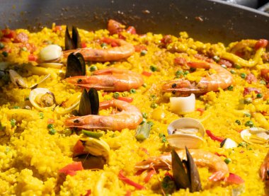 Deniz ürünleri paella, karides, midye, midye, büyük tavada sarı pirinç. Geleneksel İspanyol paella 'sı açık pazarda, sokak yemekleri