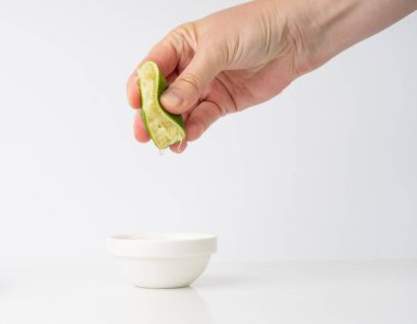 Sıkıştırılmış kireç, yarım yeşil limon sıkma, beyaz arka planda sıkılmış limon suyu, yanmış sembol, Küba Libre kokteyli.