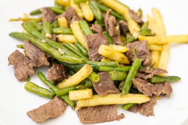 Kızarmış bifteği yeşil sarılı iple karıştırmak, yakın çekim, kızarmış Fransız fasulyesi etle karıştırmak, bulanık arkaplanda Asya yemeği, seçici odaklanma.