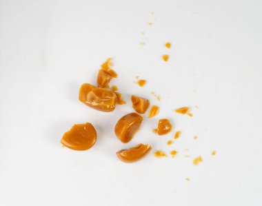 Kırık karamel şekerlemeleri izole, karamel kırıntıları, yuvarlak süt şekerleme parçaları, esmer şeker şekerler, beyaz arkaplanda küçük karamel tatlılar