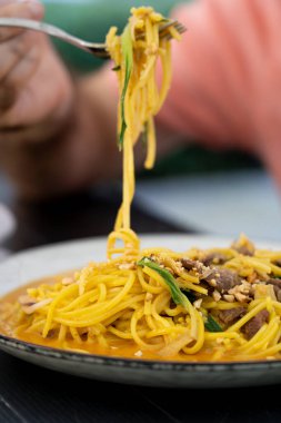 Chiang mai eriştesi, Asya baharatlı yumurta makarna etli, sarı körili şehriye çorbası Khao Soi veya Khao Sawy, Tayland yemeği yakın plan, bulanık arka plan, seçici odaklanma