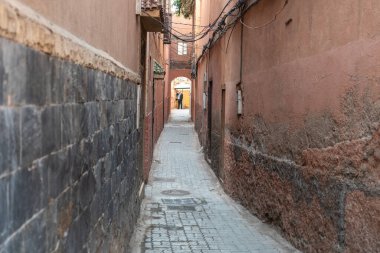 Marakeş, Fas, 10 Ocak 2024 Dar Marakeş sokakları, eski şehrin yıpranmış duvarları, otantik, tarihi Fas. Sıcak toprak tonlarında yaşlanmış binalar, kırsal cazibe, editoryal görüntü