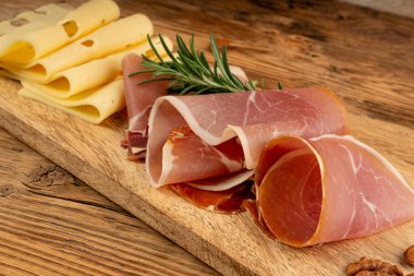 Prosciutto ile peynir tabağı, jambon, parma jambonu, kuru serrano dilimleri, iberico kapağı, peynir tabağı, çeşitli kesilmiş süt ürünleri, ahşap üzerinde kokulu Fransız peyniri.