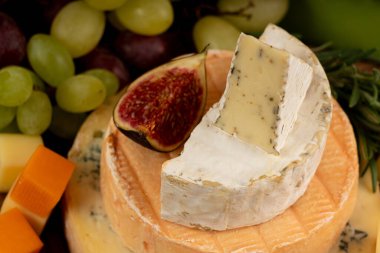 Peynir tabağı çeşitliliği, sarı, beyaz ve mavi gorgonzola tabağı, Munster, dört peynirli pano, çeşitli doğranmış süt ürünleri, ahşap üzerinde kokulu Fransız peyniri.