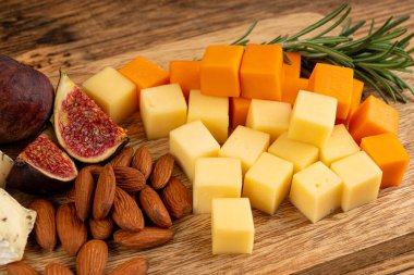 Peynir tabağı çeşitliliği, sarı, beyaz ve mavi gorgonzola tabağı, Munster, dört peynirli pano, çeşitli doğranmış süt ürünleri, ahşap üzerinde kokulu Fransız peyniri.