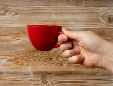 Hand Holds kupası, Ellerinde Boş Kırmızı Kupa, Kahve fincanı, Çay fincanı, Sıcak İçecek Mockup, Tahta Masa Arkaplan Arkaplanda Metin Tarafından Görünümlü Fotokopi Alanı