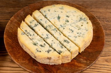 Fourme cheese, stinky french cheese, Fourme d'Ambert creamy dairy product, gourmet food, semi-hard French blue round cheese with Penicillium roqueforti spores closeup clipart