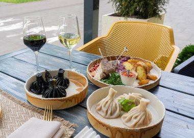 Georgian khinkali, minced meat chinkali, spicy dumplings also called dimsum, momo, jiaozi, manti, pierogi, wonton or khinkali on restaurant plate clipart