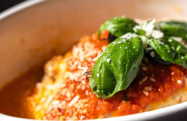 Lazanya porsiyonu, fırında lazanya, peynirli makarna, kıyma, domates. Güneşli bir yaz gününde, sokak restoranındaki masada lazanya, bulanık bir arka plan.