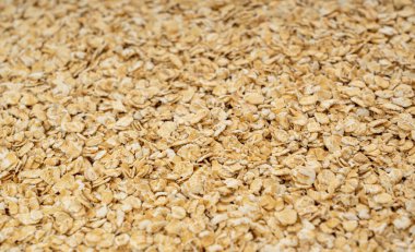 Kuru çiğ yulaf taneleri dokusu, rulo tahıl deseni, hazır lapa modeli, ince tahıllar, metin için fotokopi alanı ile sarılmış yulaf afişi, hazır arpa.