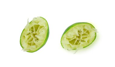Sıkışmış kireç, yarım yeşil limon sıkmak, beyaz arka planda sıkılmış limon suyu, yanmış sembol, Küba Libre kokteyli yapmak.