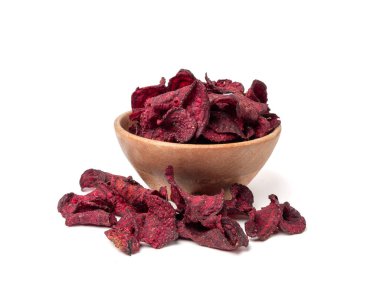 Tahta kasedeki kuru pancar parçaları izole edilmiş, dilimlenmiş kırmızı pancar gevreği yığını, pancar kökü parçaları ve patates cipsi, beyaz arka planda kurutulmuş bol yağda kızartılmış sebze kökü yığını.