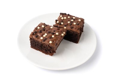 Çikolatalı kek izole edilmiş beyaz ve koyu renkli toplar serpiştirilmiş, beyaz arka planda tatlı jöleli klasik doğum günü browni karesi.