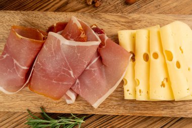 Prosciutto ile peynir tabağı, jambon, parma jambonu, kuru serrano dilimleri, iberico kapağı, peynir tabağı, çeşitli kesilmiş süt ürünleri, ahşap üzerinde kokulu Fransız peyniri.