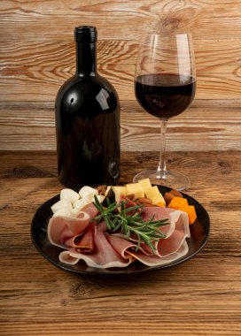 Prosciutto, jambon dilimlenmiş peynir tabağı, parma jambonu, kuru serrano dilimleri, iberico ve kırmızı şarap, peynir tabağı, çeşitli kesilmiş süt ürünleri, ahşap üzerinde kokulu Fransız peyniri.