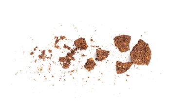 Parçalanmış çikolatalı yulaflı kurabiyeler yulaf ezmesi, fındıklı kırılmış mısır gevreği krakerleri, beyaz arka planda kakao tozu ve fıstıklı ev yapımı kurabiye parçaları.