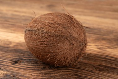 Tam hindistan cevizi, bir hindistan cevizi, tek taze tropikal palmiye meyvesi, doğal süt, doğal ahşap arka planda yağ bileşeni.