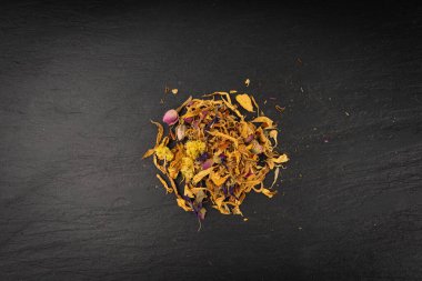 Kurutulmuş yenilebilir çiçek karışımı, Helichrysum arenaryum yığını, cüce yaprakları, siyah arka planda tıbbi bitki çayı yığını.