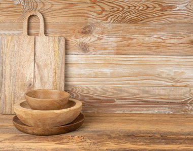 Masada boş ahşap kase, ahşap masadaki tabak yığını, hafif kırsal tabak maketi kumaşı, metin için fotokopi alanı olan eko biyo mutfak masaüstü pankartı.