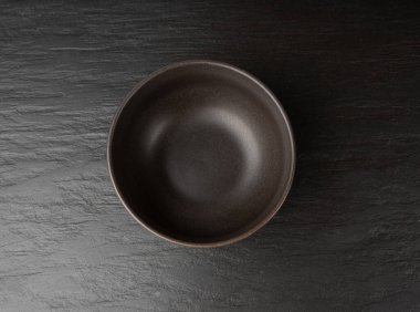 Siyah masa üstünde boş kase, koyu porselen tabak, karamsar tabak modeli, metin üst görünümü için fotokopi alanı olan mutfak afişi.