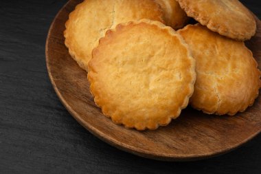 Hollanda geleneksel kurabiyeleri, Hollanda bademi doldurulmuş pasta, Hollanda badem ezmeli pasta, gevulde koek veya fındık ezmeli tart, siyah arka planda Breton tereyağlı bisküvi