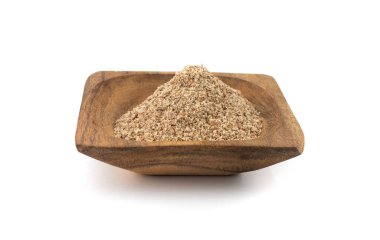 Süt tohumu tozu ahşap kasede izole, ezilmiş silybum maranum taneleri öğütülmüş kutsal süt devedikeni beyaz arka planda, bitkisel ilaç bileşeni