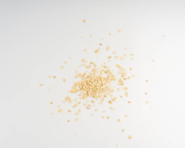 Kuru çiğ yulaf taneleri izole, yuvarlanmış düz taneler, hazır lapa, ince tahıllar, rulo yulaf, müsli veya granola için hazır arpa yığını, beyaz arka planda yulaf ezmesi.