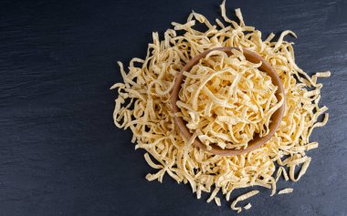 Passatelli spatzle makarna kasede, çiğ spaetzle noodle, ev yapımı Alman makarnası, siyah arkaplanda sada sahanda yumurta makarna.