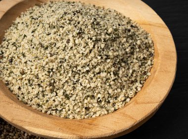 Kabuklu kenevir tohumları, soyulmuş kenevir taneleri, kabuksuz marihuana çekirdekleri, siyah arka planda yağlı protein kenevir tohumları.