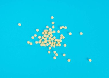 Beyaz çikolata parçaları, dağınık beyaz çikolata serpintileri, dekoratif kakao damlaları, Morsels, Kurabiye Dekorasyonu, Mavi Arkaplan Üst Görüş 'te Küçük Şekerleme Çipleri Parçaları