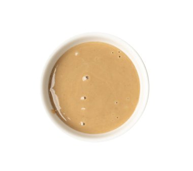 Tahini kasede izole edilmiş, susam tohumu ezmesi sürülmüş tahina sosu, doğu sosu, geleneksel doğu mutfağı malzemesi, beyaz arka planda yer susamı.