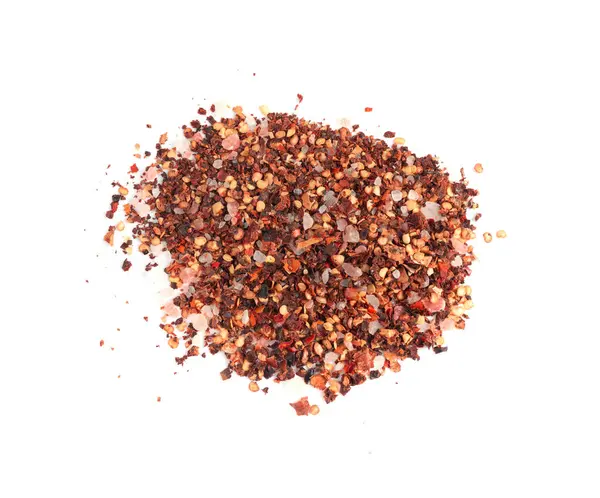 Chili ve tuz çeşnili yalıtılmış, kırmızı biberli baharat tozu, beyaz arka planda çekirdekleri olan ezilmiş acı biber taneleri.