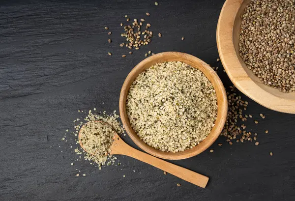 Kabuklu kenevir tohumları, soyulmuş kenevir taneleri, kabuksuz marihuana çekirdekleri, siyah arka planda yağlı protein kenevir tohumları.