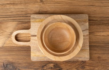 Masada boş ahşap kase, ahşap masada tabak yığını, hafif kırsal tabak modeli, metin üst görünümü için fotokopi alanı olan eko biyo mutfak masaüstü pankartı.