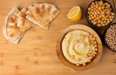 Tahta kasede humus, ev yapımı ev yapımı sos, nohut humus tahini sosu, orta doğu sosu, kırsal arka planda Arap humusu.