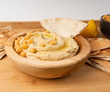 Tahta kasede humus, ev yapımı ev yapımı sos, nohut humus tahini sosu, orta doğu sosu, kırsal arka planda Arap humusu.