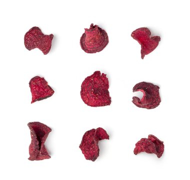 Kuru pancar cipsleri izole edilmiş, dilimlenmiş kırmızı pancar gevreği yığını, pancar kökü parçaları ve cipsler, beyaz arka planda kurutulmuş bol yağda kızartılmış sebze kökü yığını.