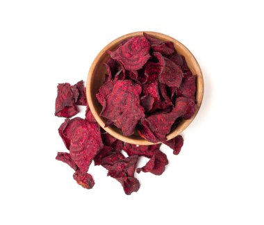 Tahta kasedeki kuru pancar parçaları izole edilmiş, dilimlenmiş kırmızı pancar gevreği yığını, pancar kökü parçaları ve patates cipsi, beyaz arka planda kurutulmuş bol yağda kızartılmış sebze kökü yığını.