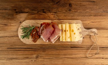 Prosciutto ile peynir tabağı, jambon, parma jambonu, kuru serrano dilimleri, iberico kapağı, peynir tabağı, çeşitli kesilmiş süt ürünleri, ahşap üzerinde kokulu Fransız peyniri.