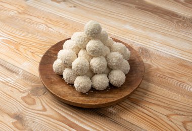 Hindistan cevizi şekeri yığını, hindistan cevizi topu. Beyaz trüf mantarı, Hint ladoo 'su ya da tatlı kremalı laddu ve hindistan cevizli gevrek ev yapımı pralin tatlısı, ahşap tabakta barfi.