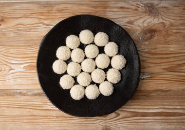 Hindistan cevizi şekeri yığını, hindistan cevizi topu. Beyaz trüf mantarı, Hint ladoo 'su ya da tatlı kremalı laddu ve hindistan cevizli gevrek ev yapımı pralin tatlısı, siyah tabakta barfi.