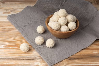 Hindistan cevizi şekeri yığını, hindistan cevizi topu. Beyaz trüf mantarı, Hint ladoo 'su ya da tatlı kremalı laddu ve hindistan cevizli gevrek, ev yapımı pralin tatlısı, ahşap kasede barfi yakın plan.